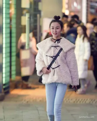 街拍小姐姐一件白色的絨毛上衣搭配牛仔褲，非常的顯精神