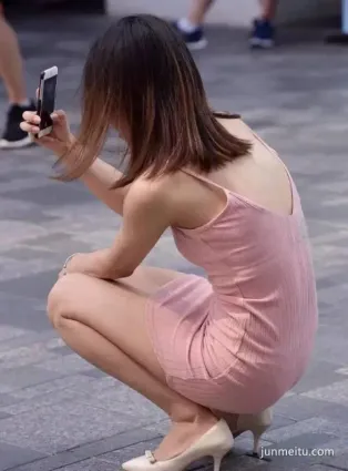 街拍抄底粉色裙小姐姐自拍上瘾，蹲下裡面也是粉色的