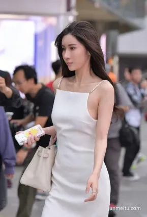 街拍穿吊帶白裙的苗條動人大羙女，在街上很靓麗啊