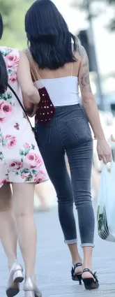 街拍高挑緊身牛仔褲渾圓挺翹修長雙腿露肩飽滿氣質女郎