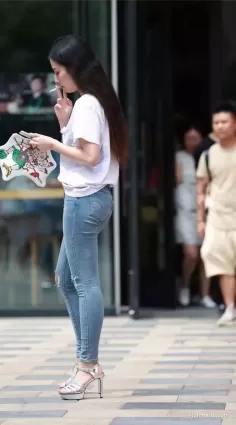街拍高挑大長腿緊身破洞牛仔褲高跟鞋抽煙氣質女郎