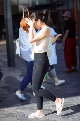 街拍陽光下黑色緊身褲豐腴身材女郎