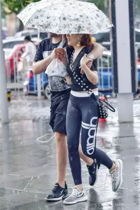 街拍雨中行進的緊身褲苗條修長雙腿氣質漂亮女郎
