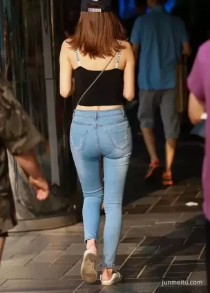 街拍高挑緊身破洞牛仔褲豐腴長腿渾圓挺翹露臍露肩女郎